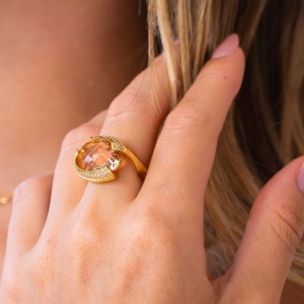 Anello placcato oro giallo a fascia aperta con cristallo centrale sfaccettato peach circondato da zirconi incastonati XAN233DO