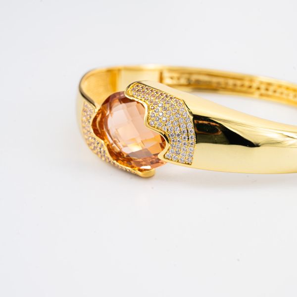 Bracciale rigido placcato oro giallo a fascia larga con cristallo centrale peach a forma ovale XB1064DO