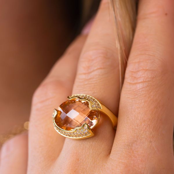 Anello placcato oro giallo a fascia aperta con cristallo centrale sfaccettato peach circondato da zirconi incastonati XAN233DO